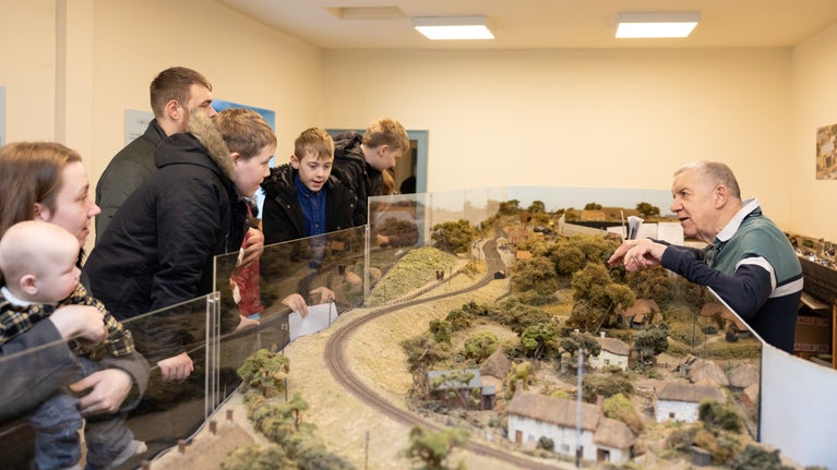 Railway volunteer engaging with visiting family and operating the model railway.